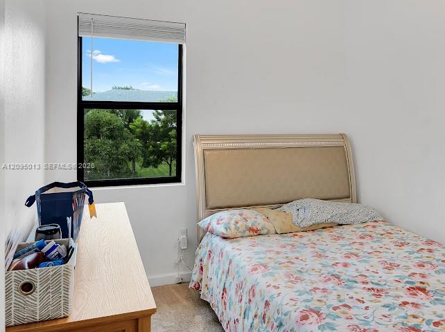 Neutral-toned interior featuring wall-to-wall carpeting and a single-hung window with a horizontal blind