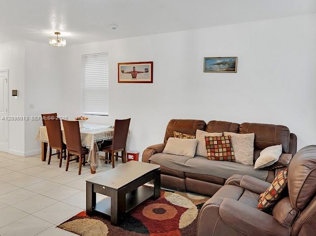 Neutral-toned ceramic tile flooring, clean white wall finishes, and a contemporary multi-bulb ceiling light fixture Neutral-toned ceramic tile flooring, clean white wall finishes, and a contemporary multi-bulb ceiling light fixture