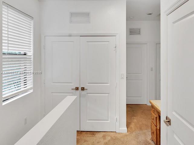 Double doors featuring brushed nickel hardware, horizontal slat window blinds, and solid-core interior doors