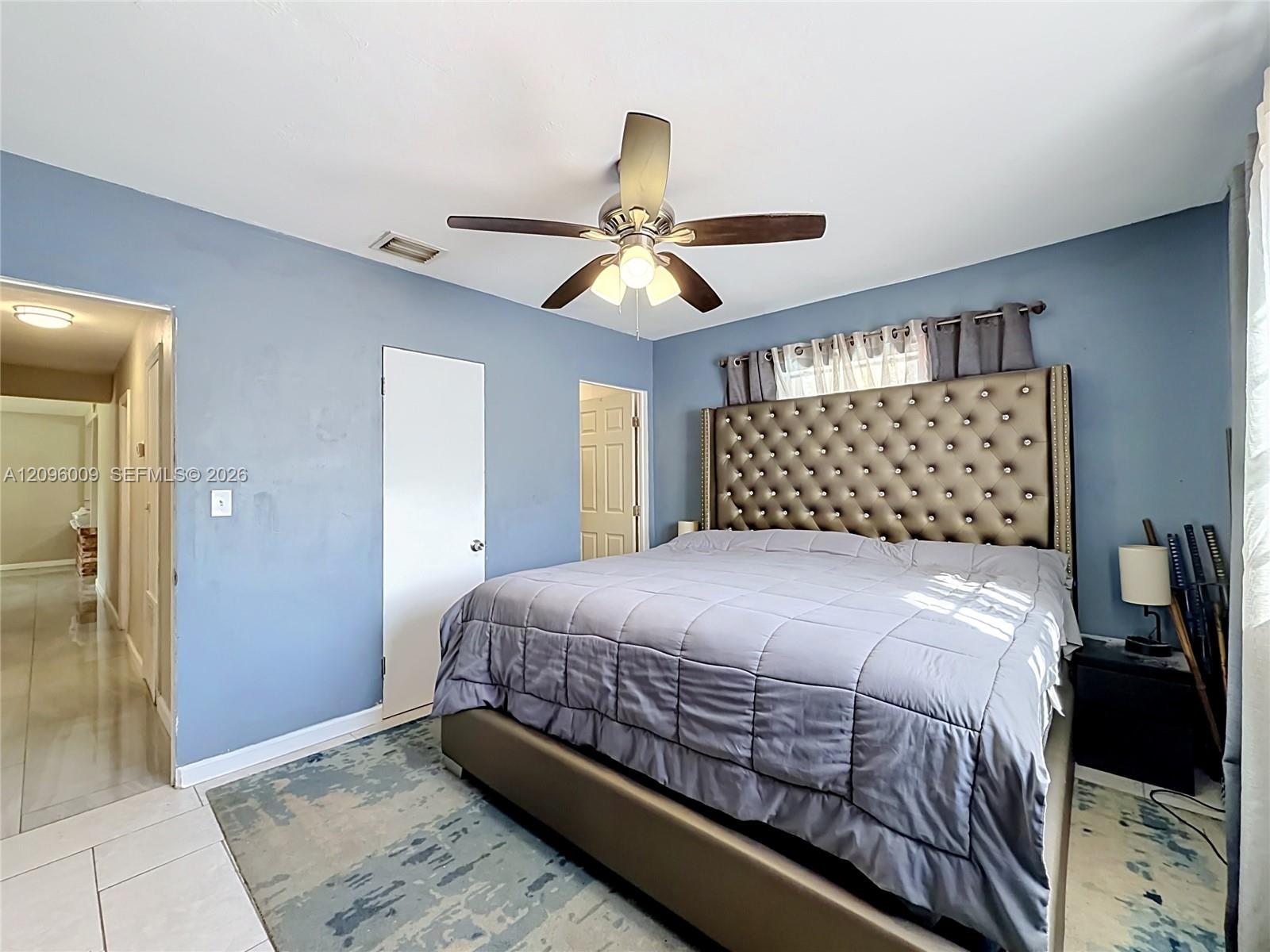 Room featuring ceramic tile flooring, neutral wall paint, and a multi-blade ceiling fan with integrated lighting