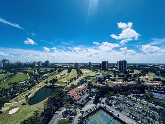 Aerial perspective featuring a golf course, expansive water features, and tennis courts