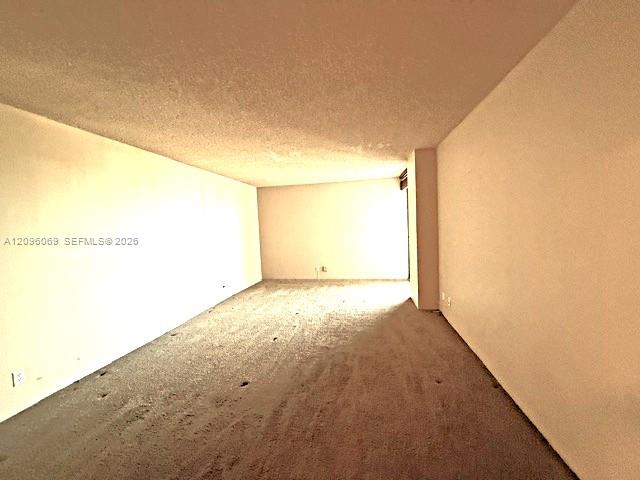 Expansive interior room featuring neutral wall finishes and wall-to-wall carpeting