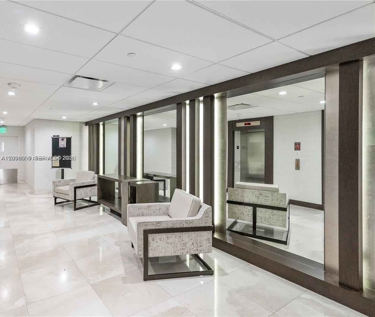 Polished stone flooring, floor-to-ceiling mirrors, recessed lighting, and integrated wall-panel accent lighting
