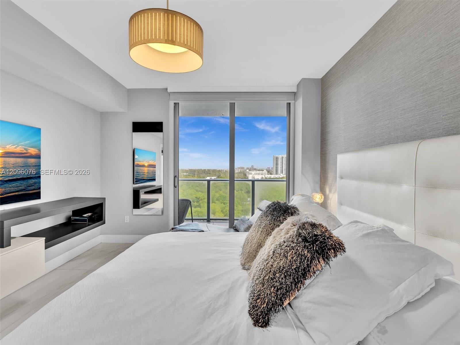 Floor-to-ceiling glass sliding doors, textured accent wall, drum-style pendant light fixture, built-in cantilevered wall shelf, and balcony with metal railing