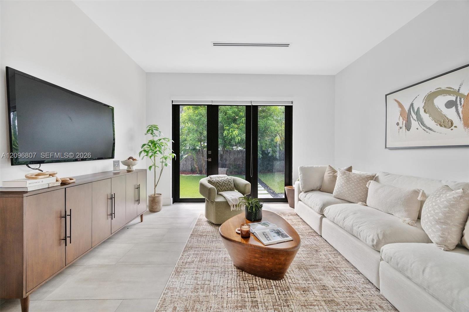 Neutral-toned interior featuring large-format tile flooring, recessed ceiling lighting, and black-framed French doors Neutral-toned interior featuring large-format tile flooring, recessed ceiling lighting, and black-framed French doors