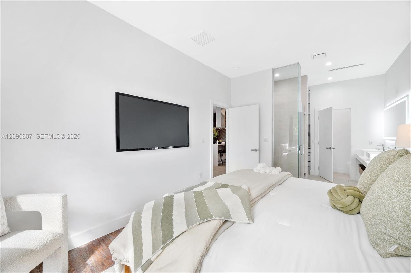 Interior space featuring wood-finish flooring, recessed lighting, and a glass-enclosed shower stall
