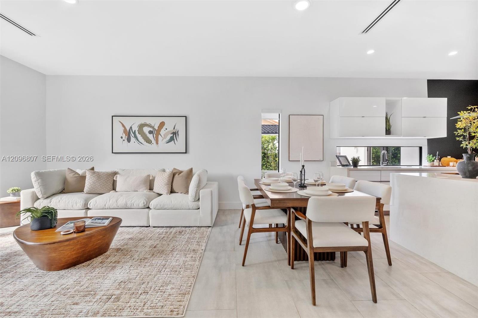 Open-concept space featuring high ceilings with recessed lighting, tile flooring, modern white cabinetry, and horizontal window placement