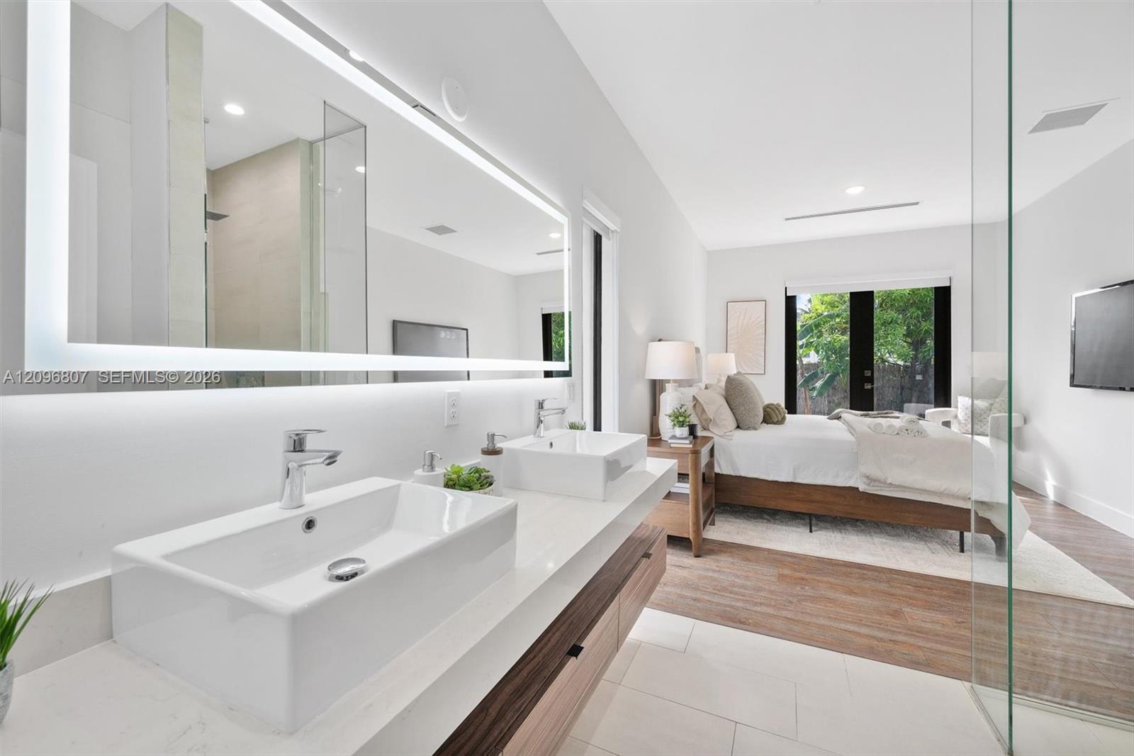 Floating dual-sink vanity with a countertop, rectangular vessel sinks, chrome faucets, and an oversized LED-backlit mirror