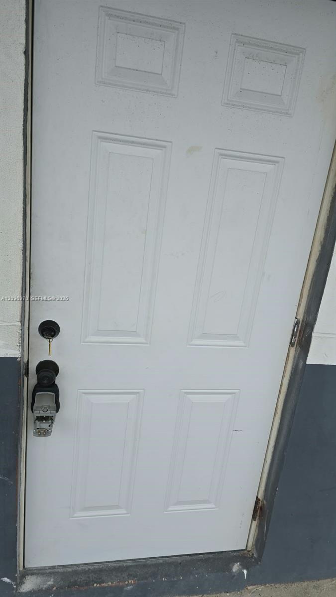 Six-panel white door with dual deadbolt and keyless entry hardware Six-panel white door with dual deadbolt and keyless entry hardware