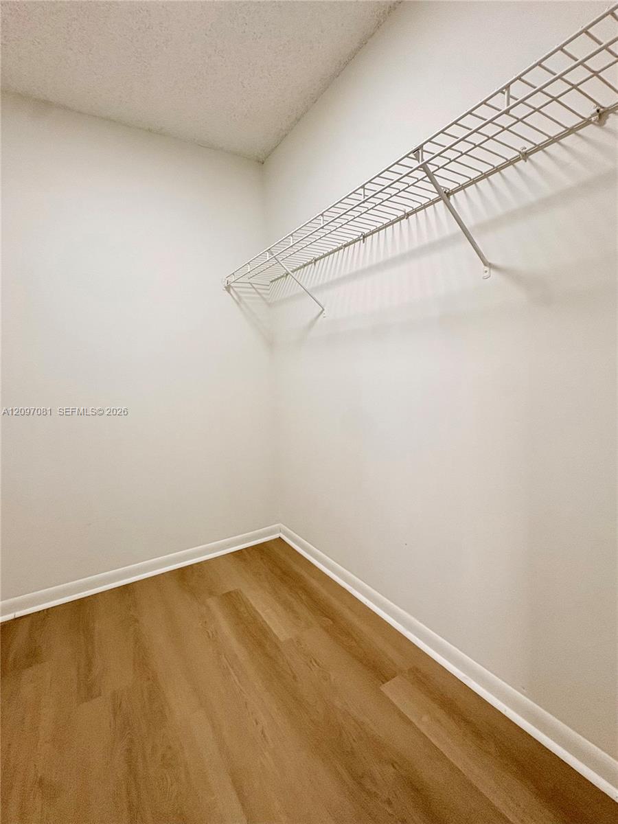 Storage area featuring wood-finish flooring and white wire shelving