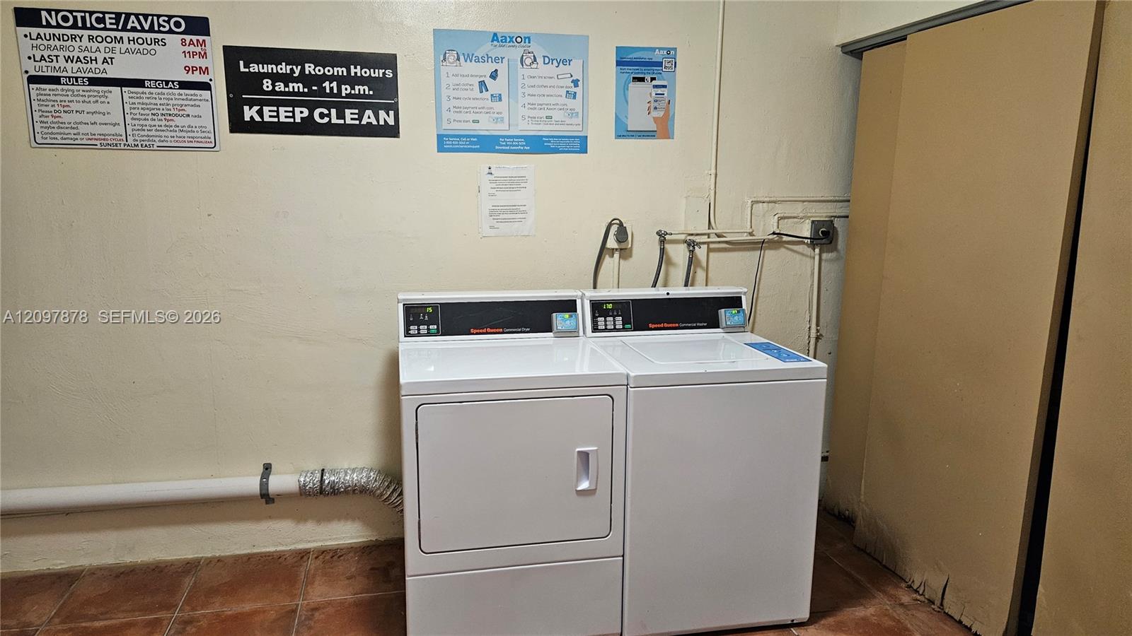 Laundry area featuring side-by-side coin-operated appliances and tiled flooring