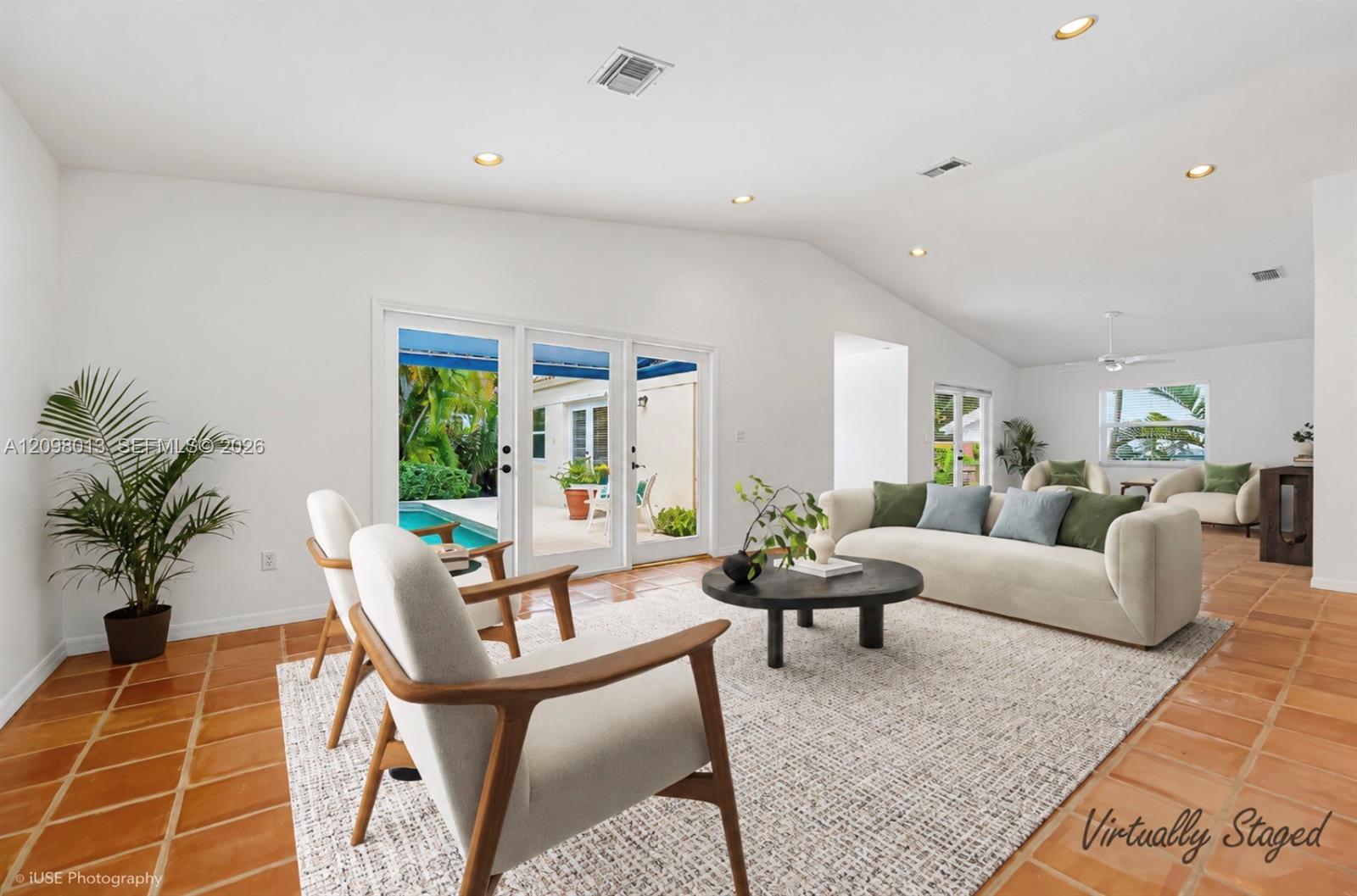 Vaulted ceilings, French Doors lead out to the poolVirtually staged photo.