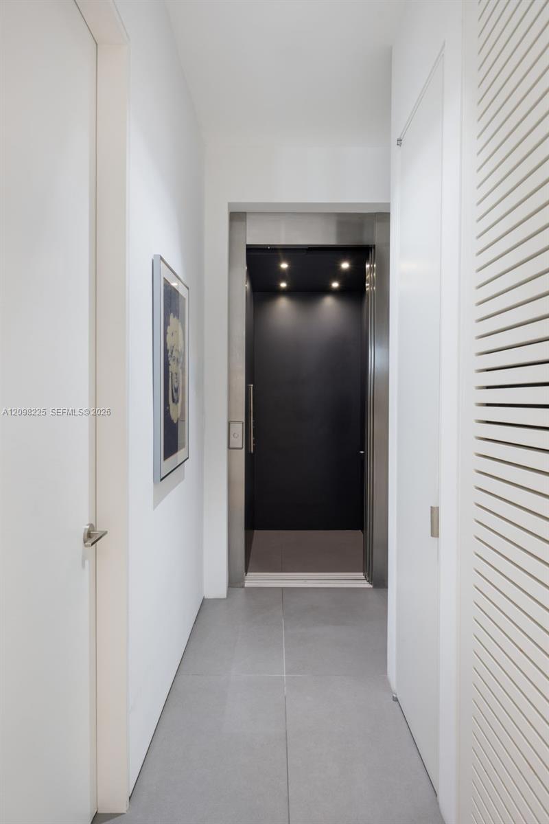 Private elevator with stainless steel trim, recessed ceiling lighting, and large-format porcelain tile flooring