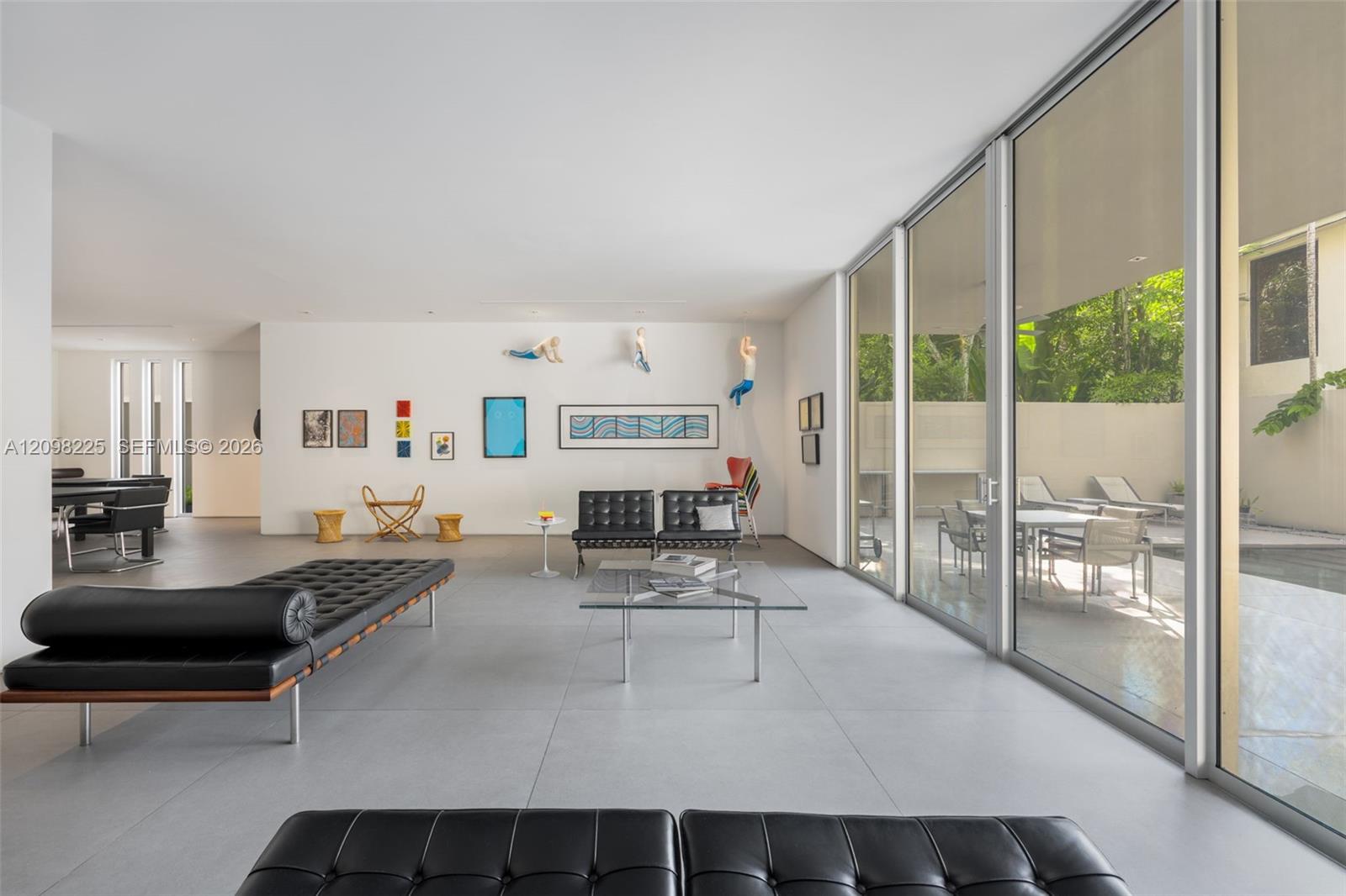 Open-concept interior featuring large-format tile flooring, floor-to-ceiling glass walls, and recessed lighting