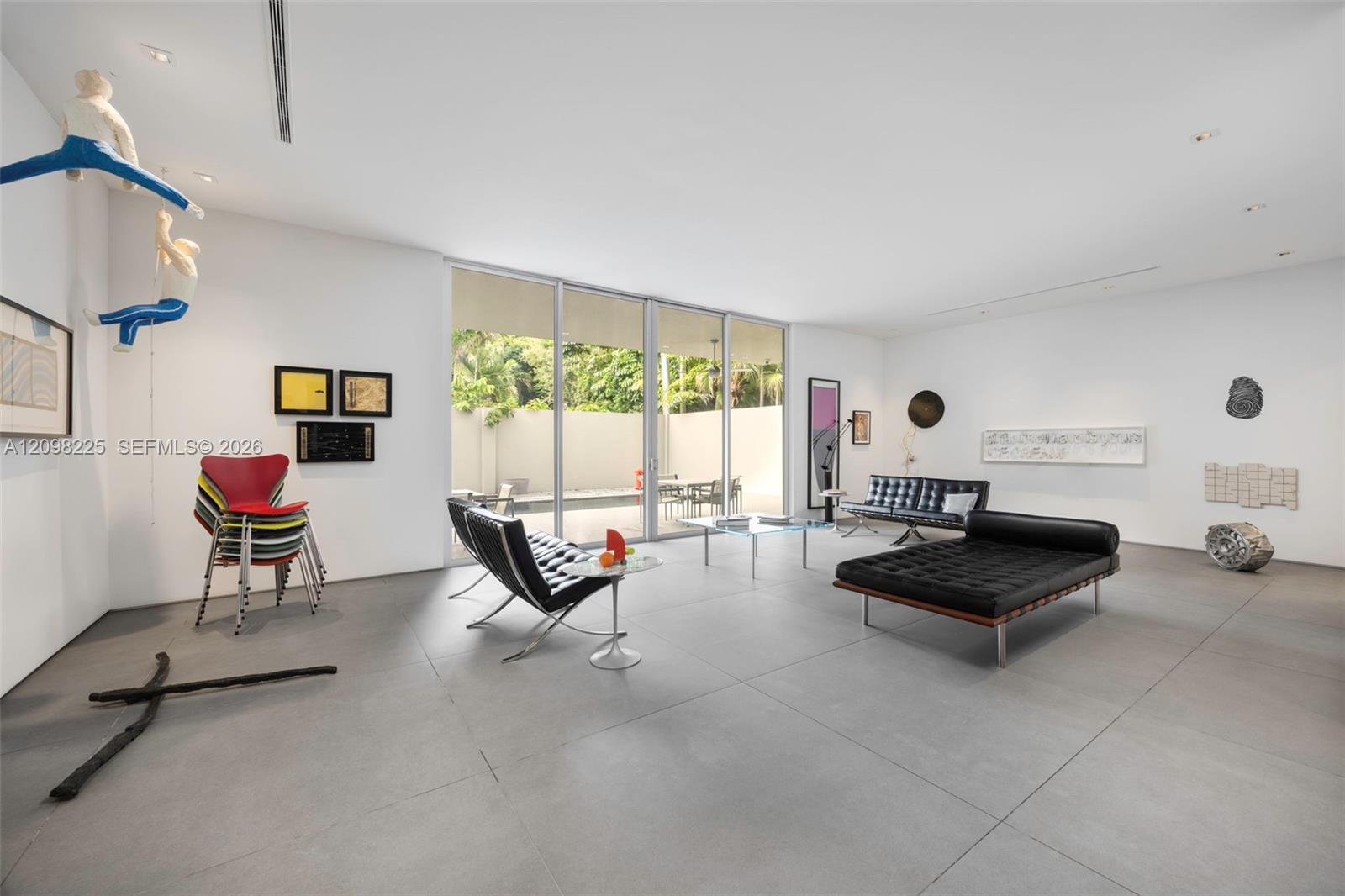 Large-format tile flooring, expansive floor-to-ceiling glass sliding doors, and recessed ceiling lighting
