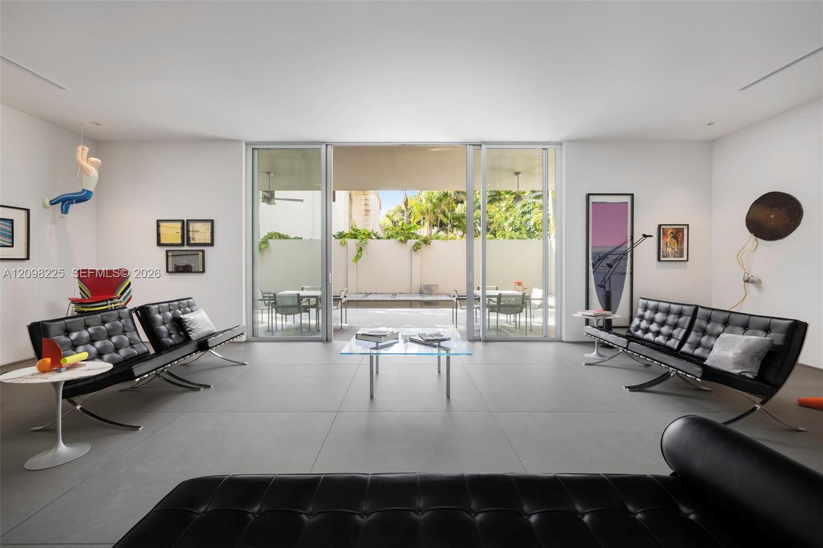 Large-format tile flooring, recessed ceiling lighting, and sliding glass panel doors opening to an exterior patio space