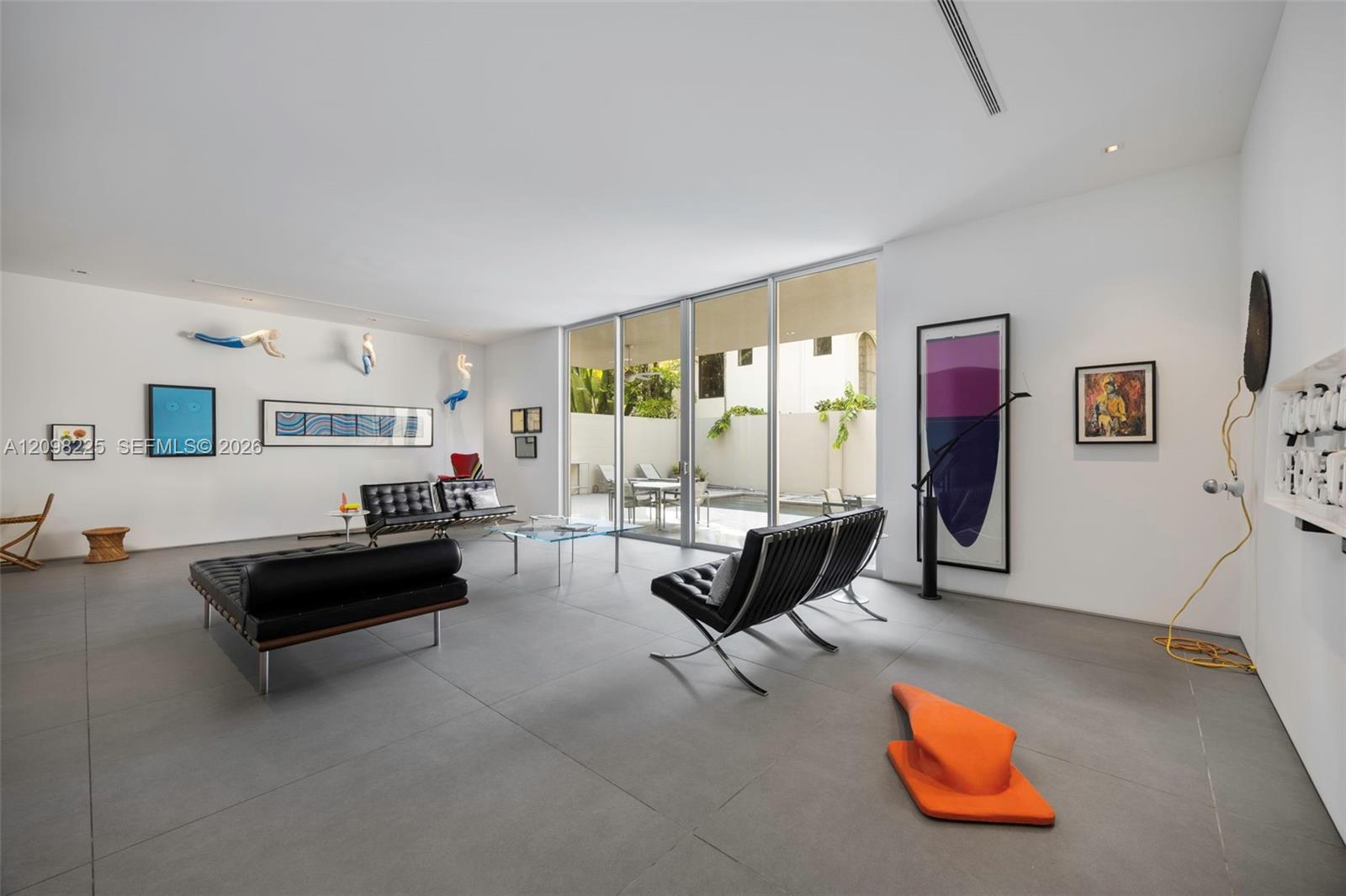 Large-format tile flooring, floor-to-ceiling glass sliding doors, recessed lighting, and smooth white walls
