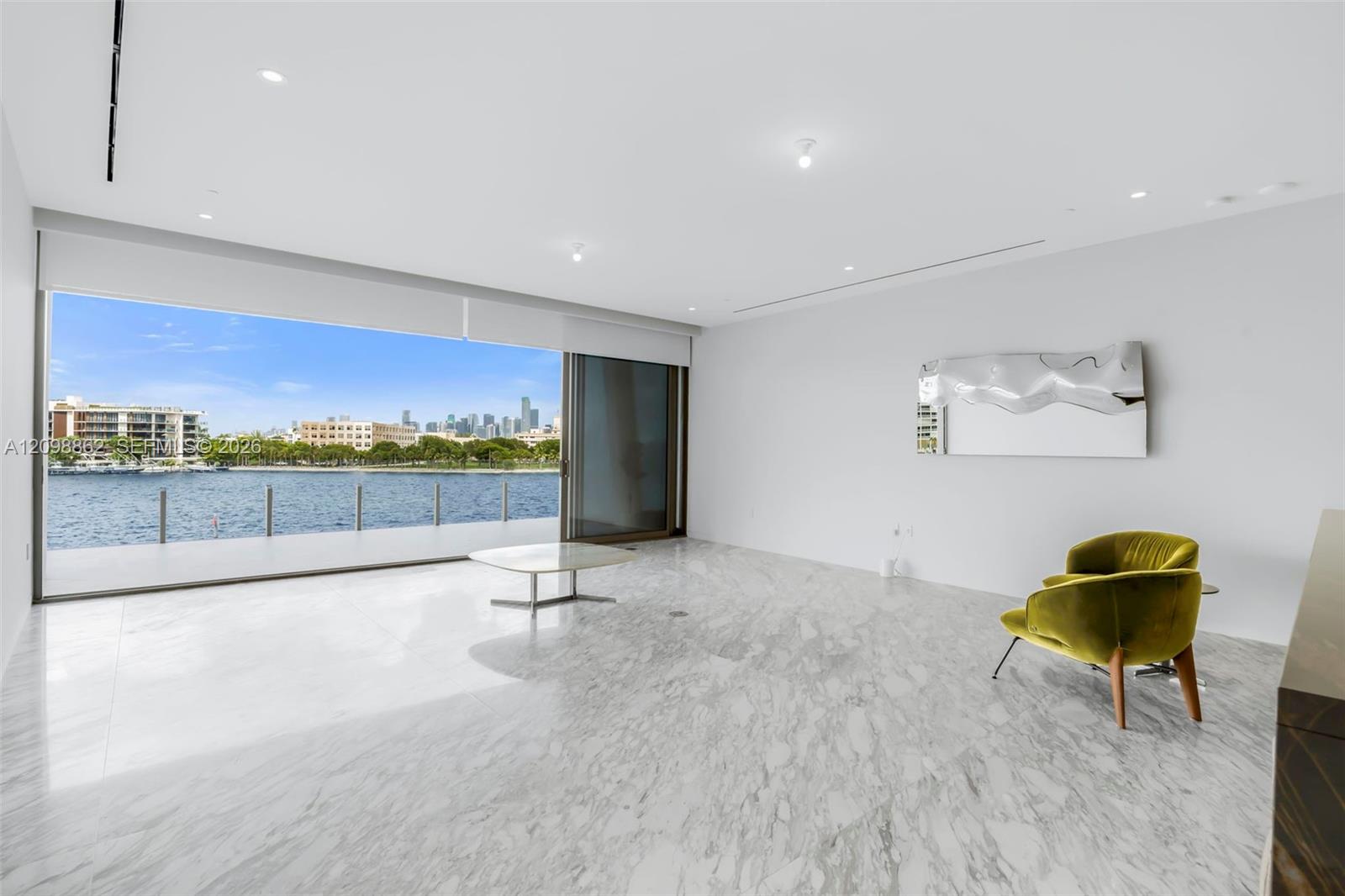 Large-format tile flooring, expansive sliding glass doors, recessed lighting, and water-fronting balcony Large-format tile flooring, expansive sliding glass doors, recessed lighting, and water-fronting balcony