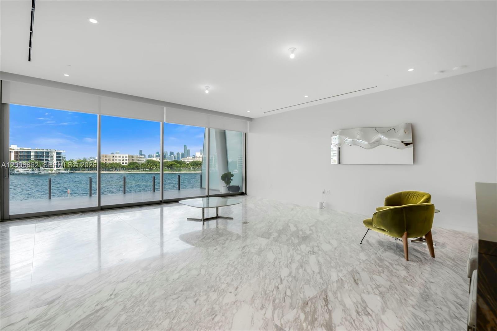 Floor-to-ceiling glass windows, polished stone flooring, recessed ceiling lighting, and minimalist wall surfaces