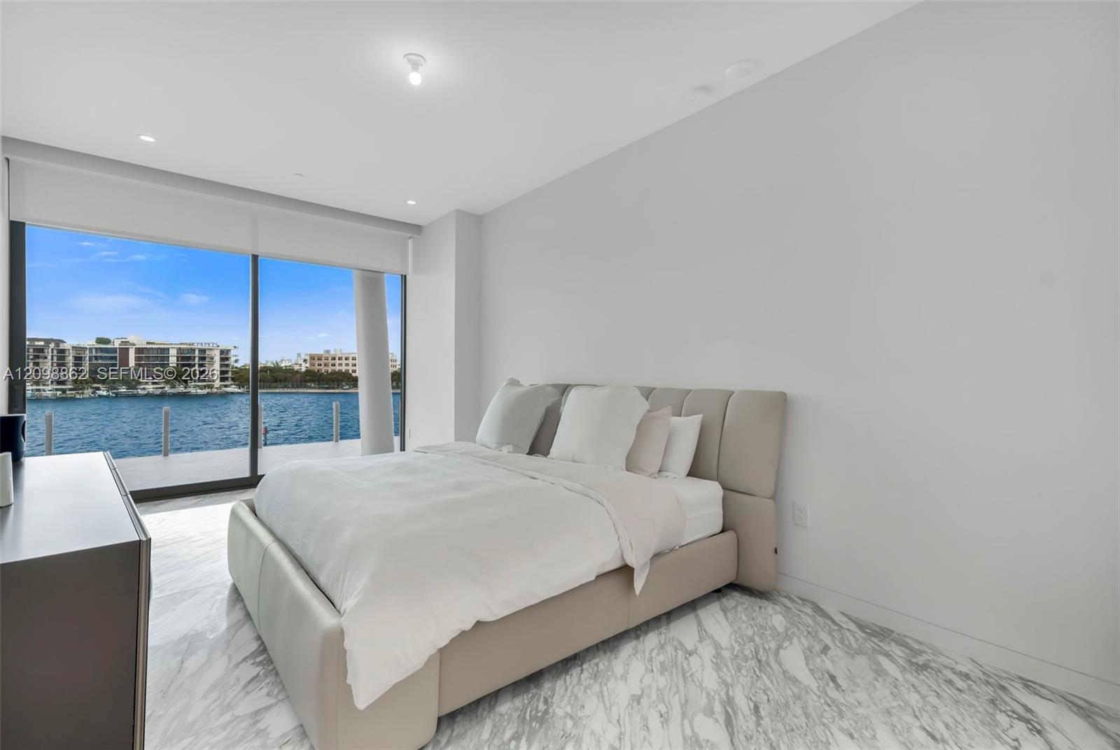 Floor-to-ceiling sliding glass doors, stone-finish flooring, and recessed ceiling lighting