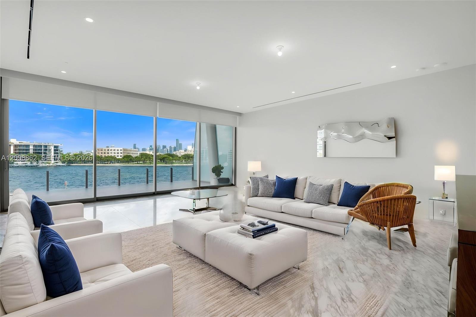 Floor-to-ceiling glass wall, polished tile flooring, recessed ceiling lighting, and waterfront scenery