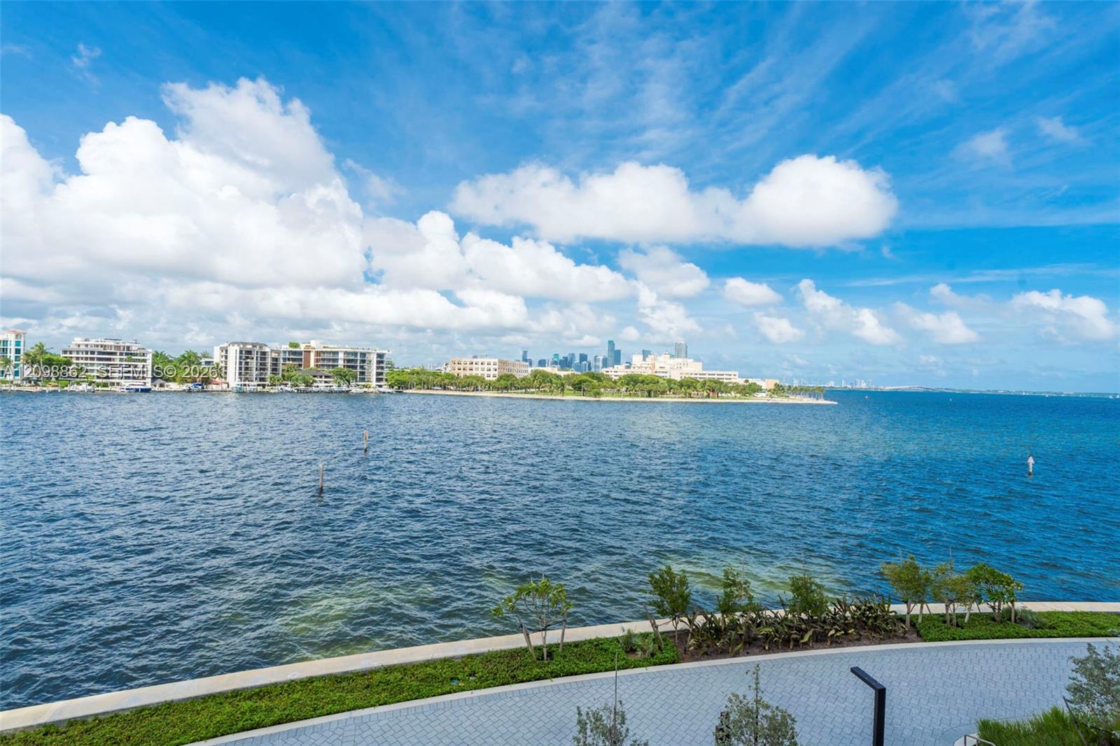 Waterfront location with direct bay frontage, stone-paver walkway, and manicured landscaping