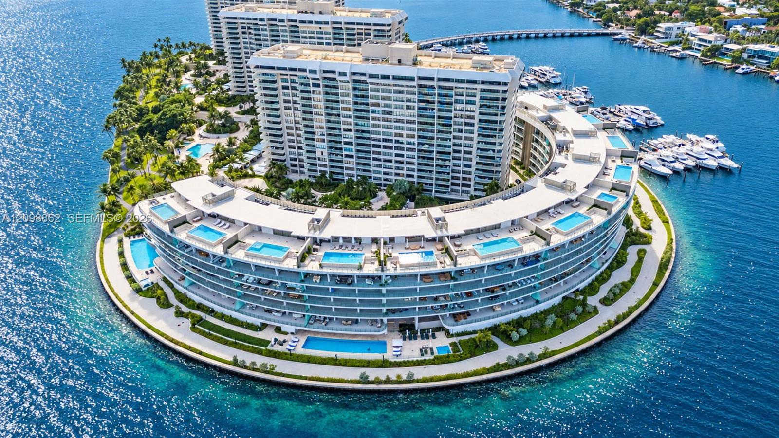 Waterfront residential complex featuring multiple private terrace swimming pools, expansive balconies, extensive hardscaped grounds, and deep-water marina access