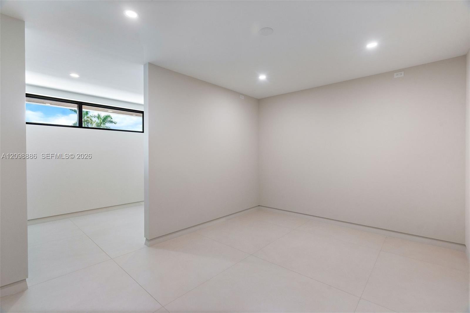 Neutral-toned interior featuring large-format tile flooring, recessed ceiling lighting, and a horizontal clerestory window