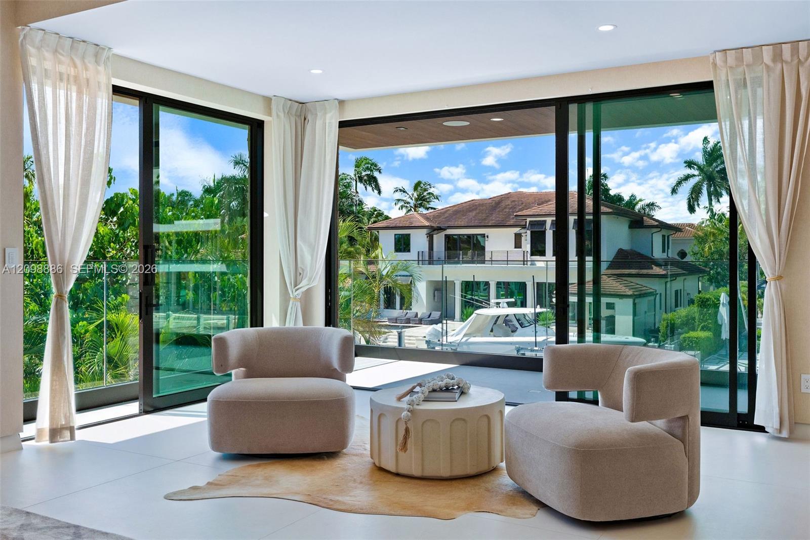 Floor-to-ceiling sliding glass walls, recessed ceiling lighting, and light-toned tile flooring
