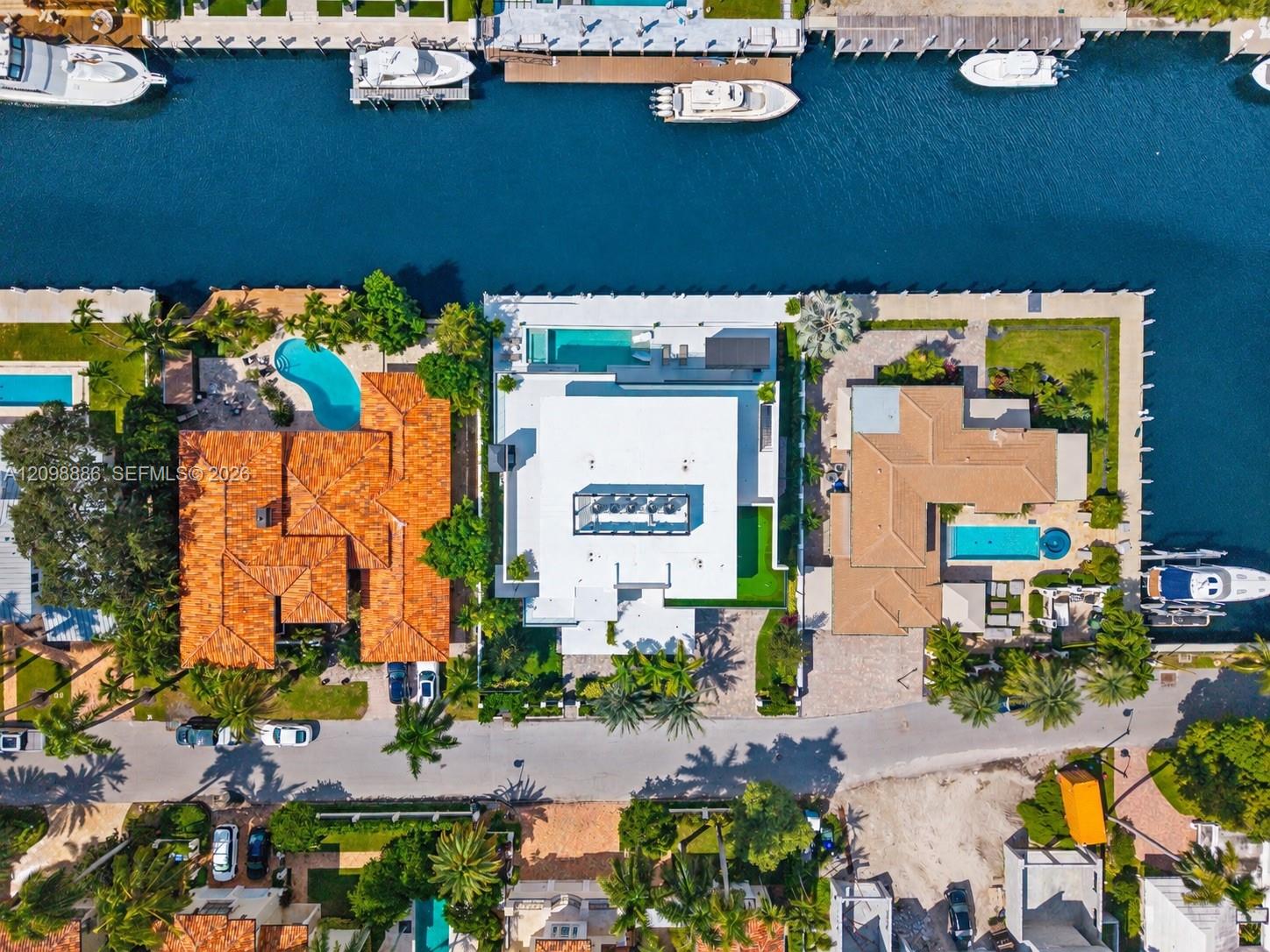 Waterfront property featuring a private dock, swimming pool, and paved driveway