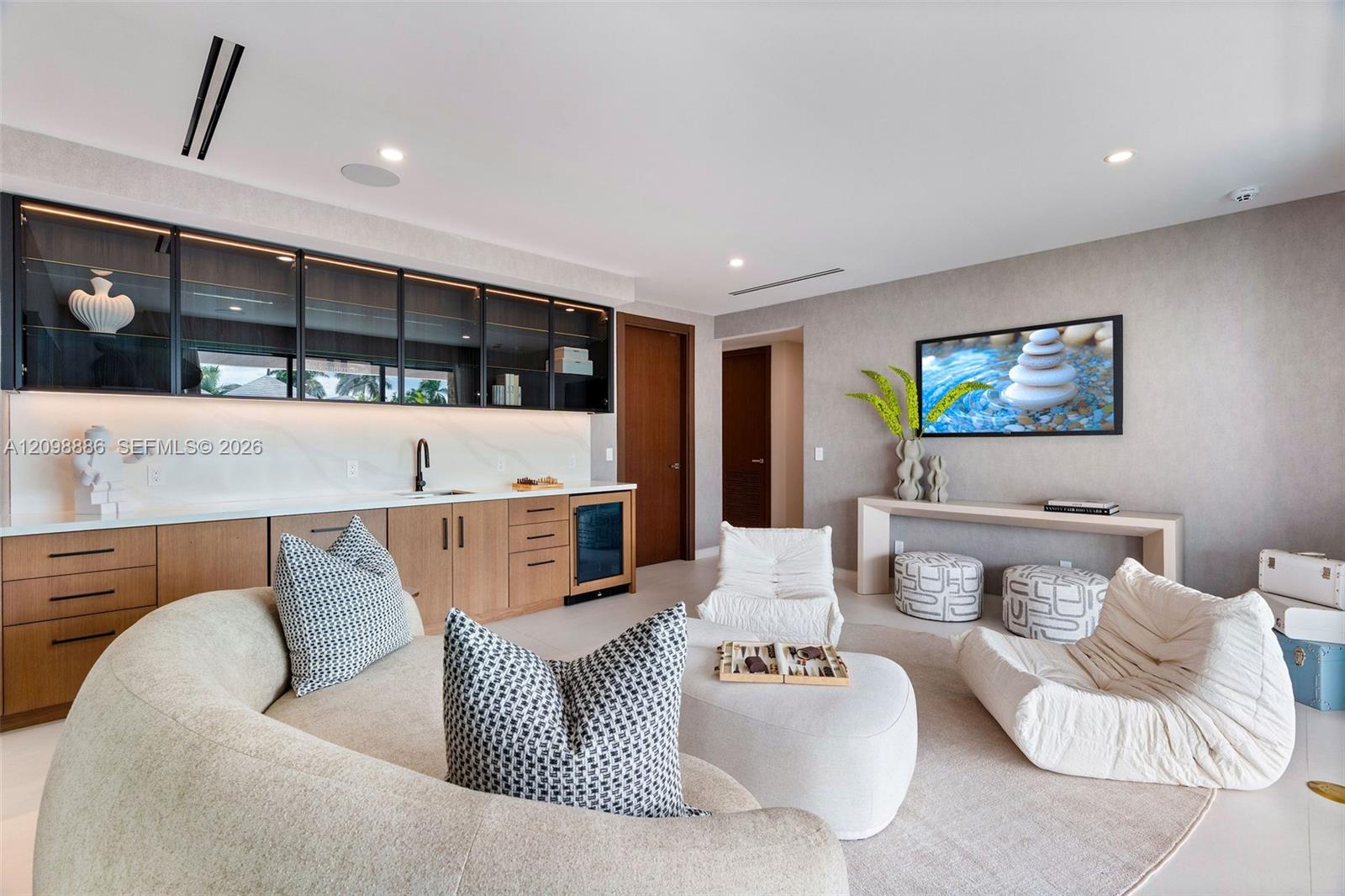 Built-in bar featuring wood cabinetry, stone-surface countertop, under-cabinet lighting, glass-front upper storage, and an integrated beverage refrigerator