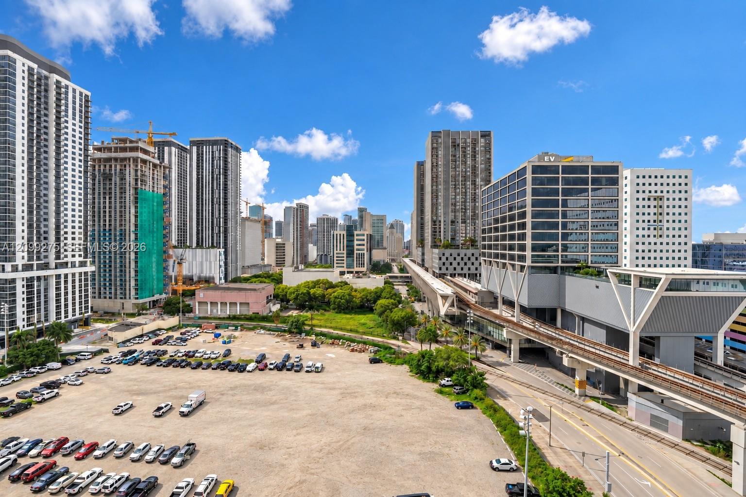 Large open parking area with ample space for multiple vehicles, conveniently located near high-rise buildings, commercial properties, and public transportation.