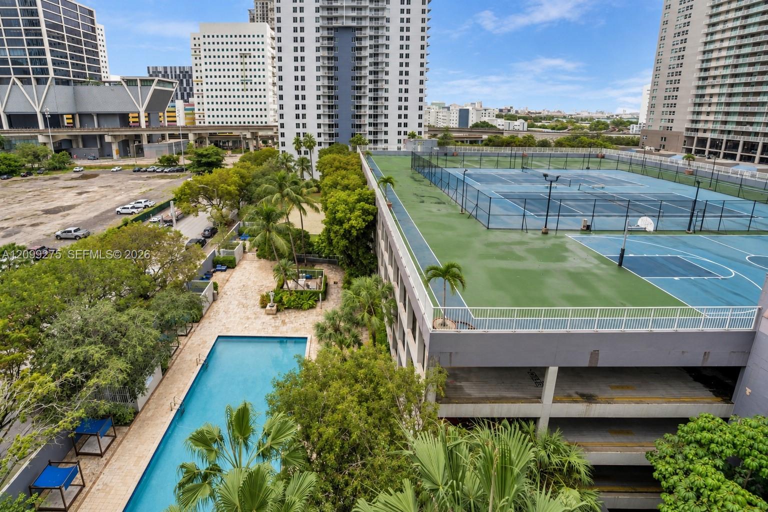Enjoy a resort-style setting with a swimming pool, sun deck, tennis courts, basketball courts, and lush tropical landscaping.