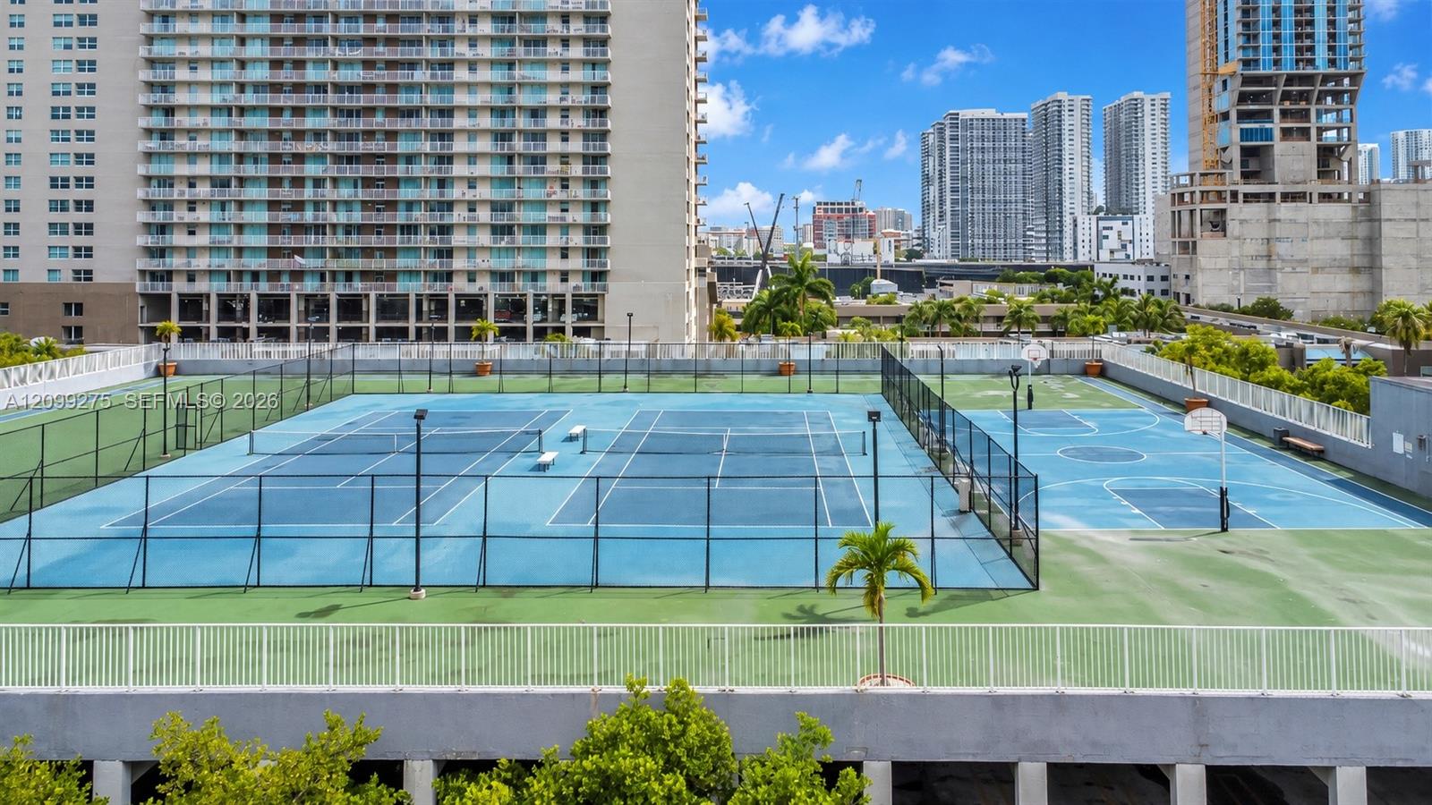 Recreational amenities featuring tennis courts, basketball courts, and panoramic views of Miamis high-rise skyline.