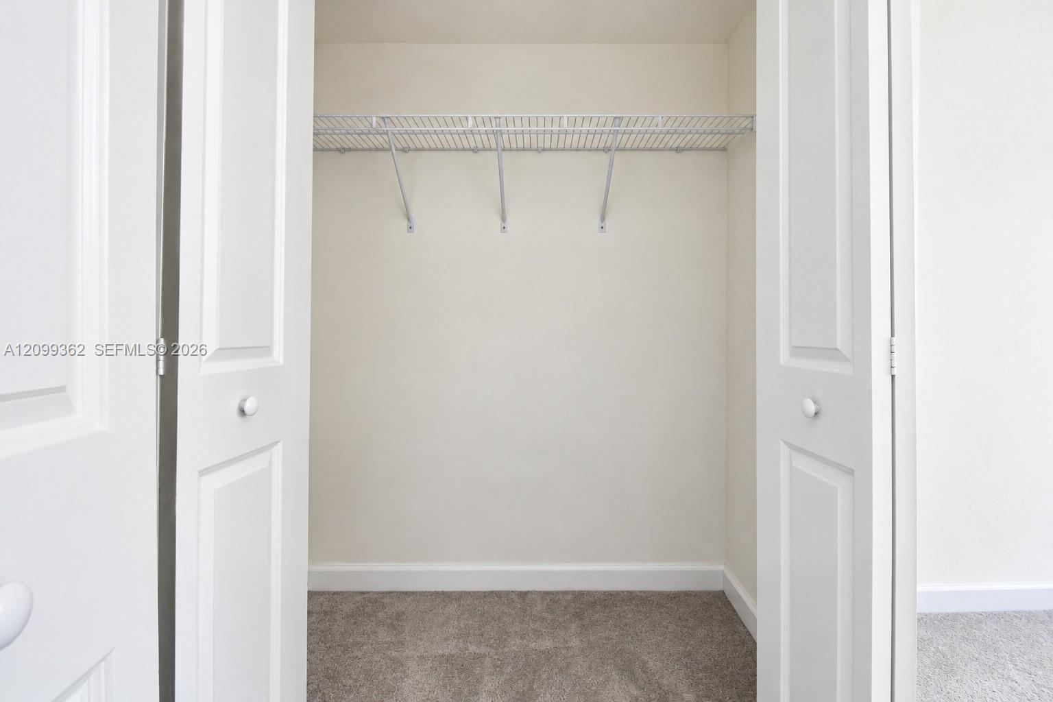 Closet featuring white bi-fold doors and overhead wire shelving