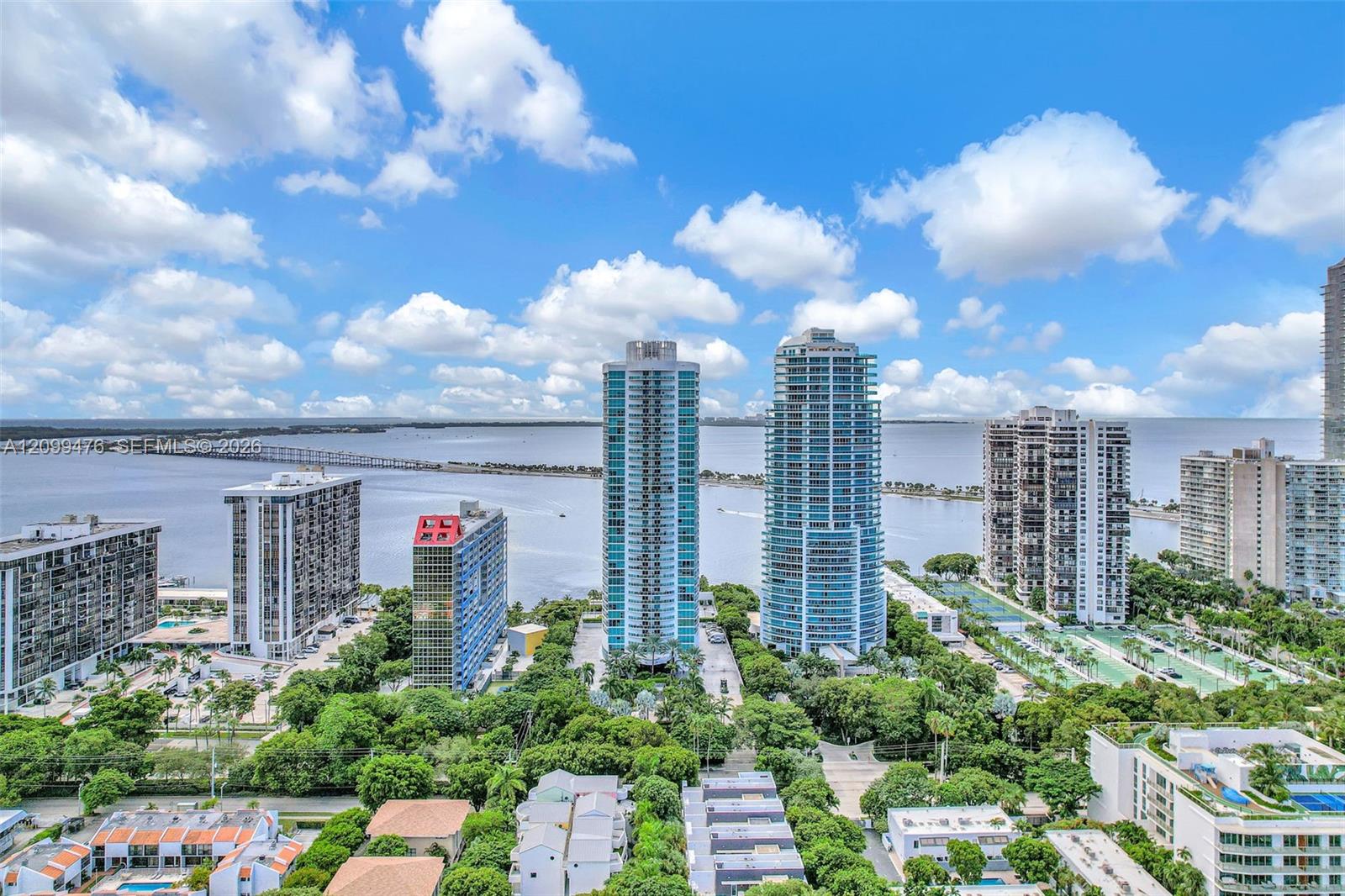 High-rise cityscape featuring extensive waterfront proximity, mature canopy coverage, and expansive sky exposure
