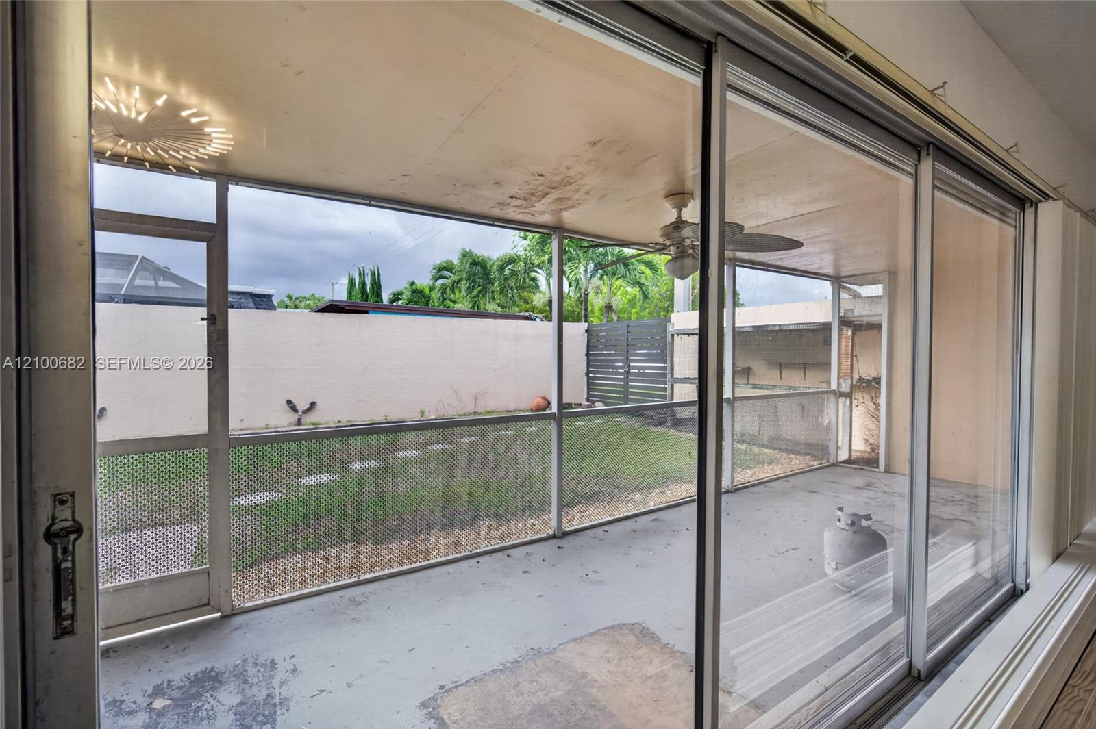 Screened-in patio with concrete flooringview access to a fenced yard *