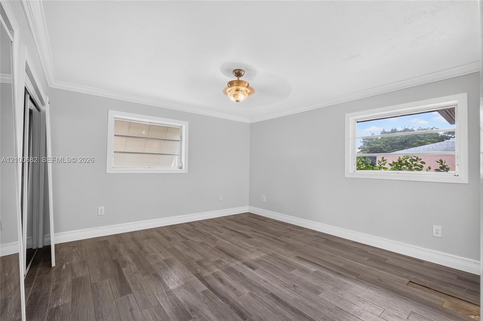 Main bedroom featuring crown molding, newer baseboards and framed windows *