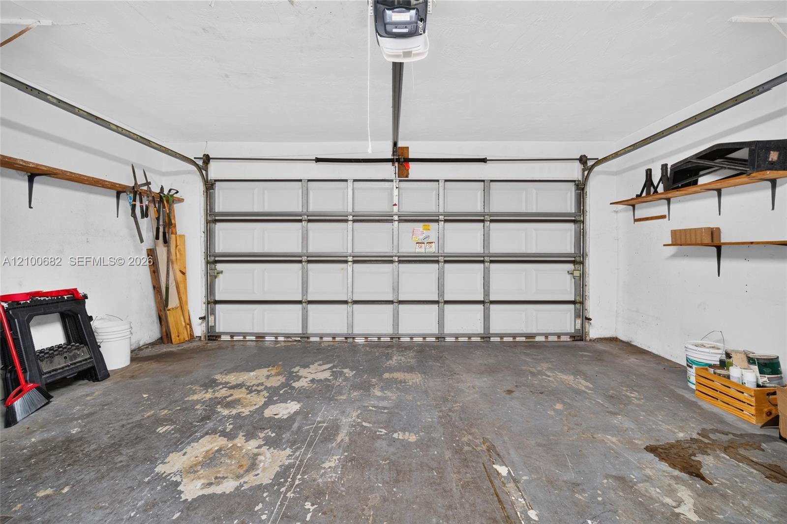 Enclosed garage featuring a newer garage door*