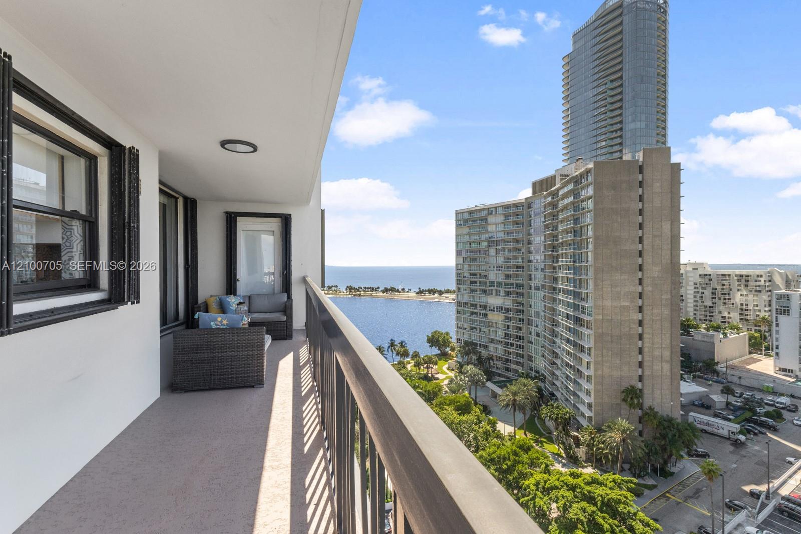 Covered balcony featuring concrete flooring, a metal railing, and direct water access