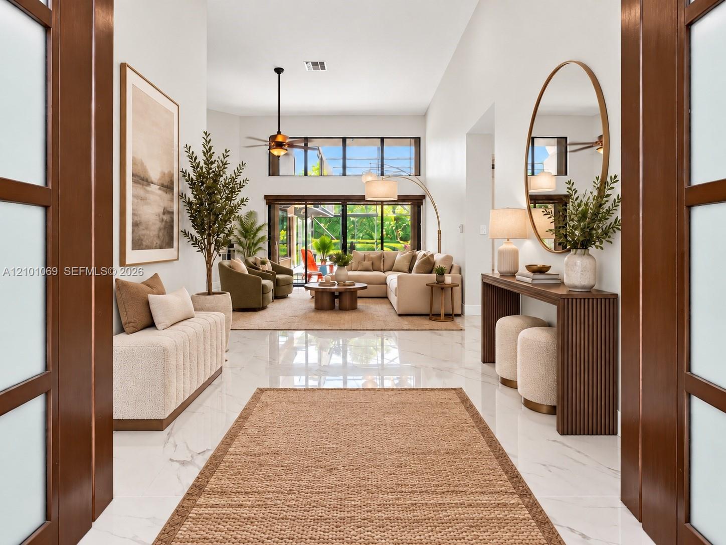 Impact front doors open to living room and dining room. virtually staged