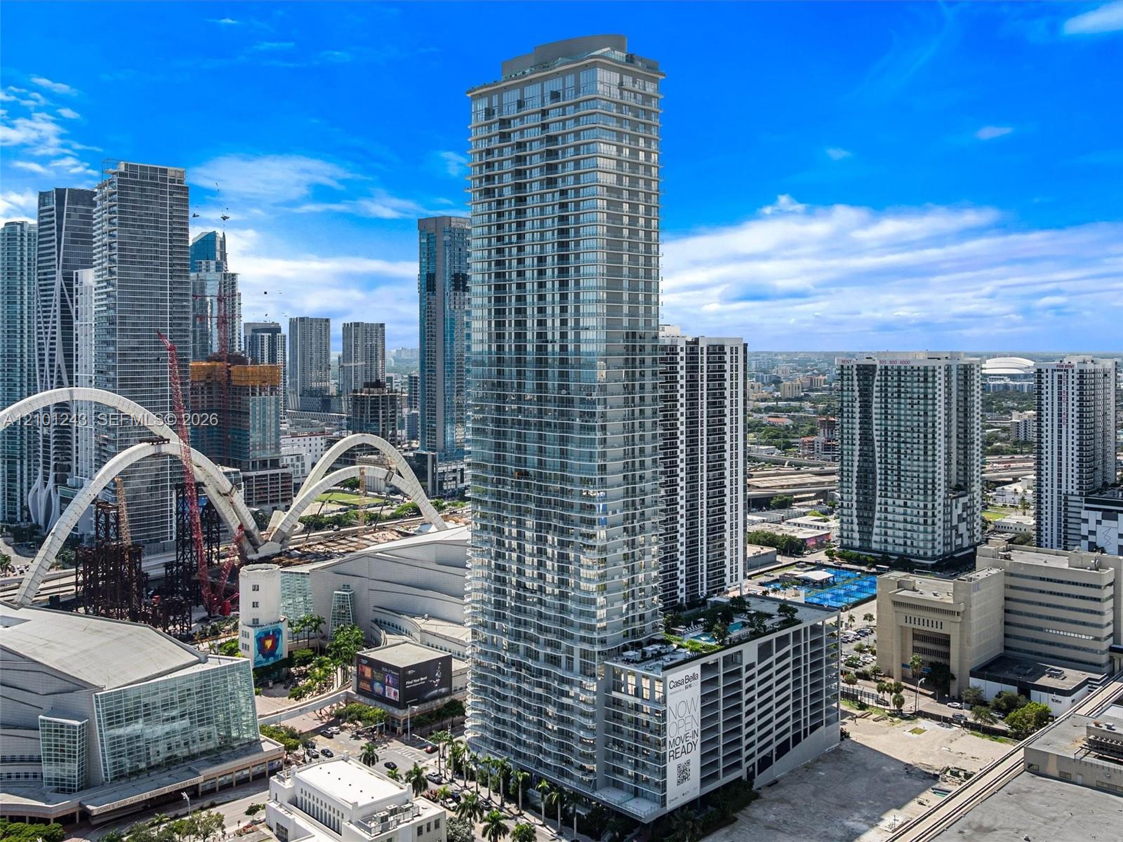 High-rise architectural tower featuring floor-to-ceiling glass paneling, a multi-level structure, private balconies, and an elevated outdoor deck