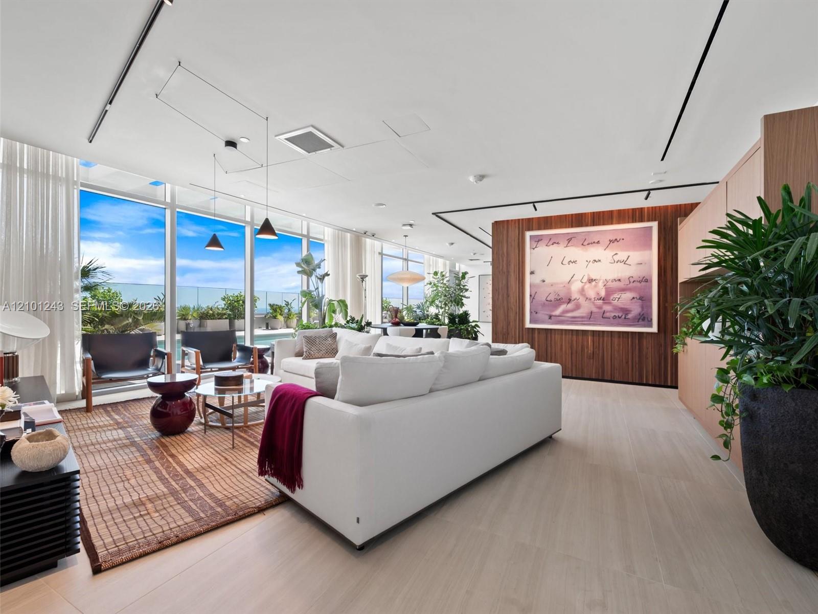 Floor-to-ceiling glass walls, wood-finish flooring, linear track lighting, and a floor-to-ceiling wood-panel feature wall