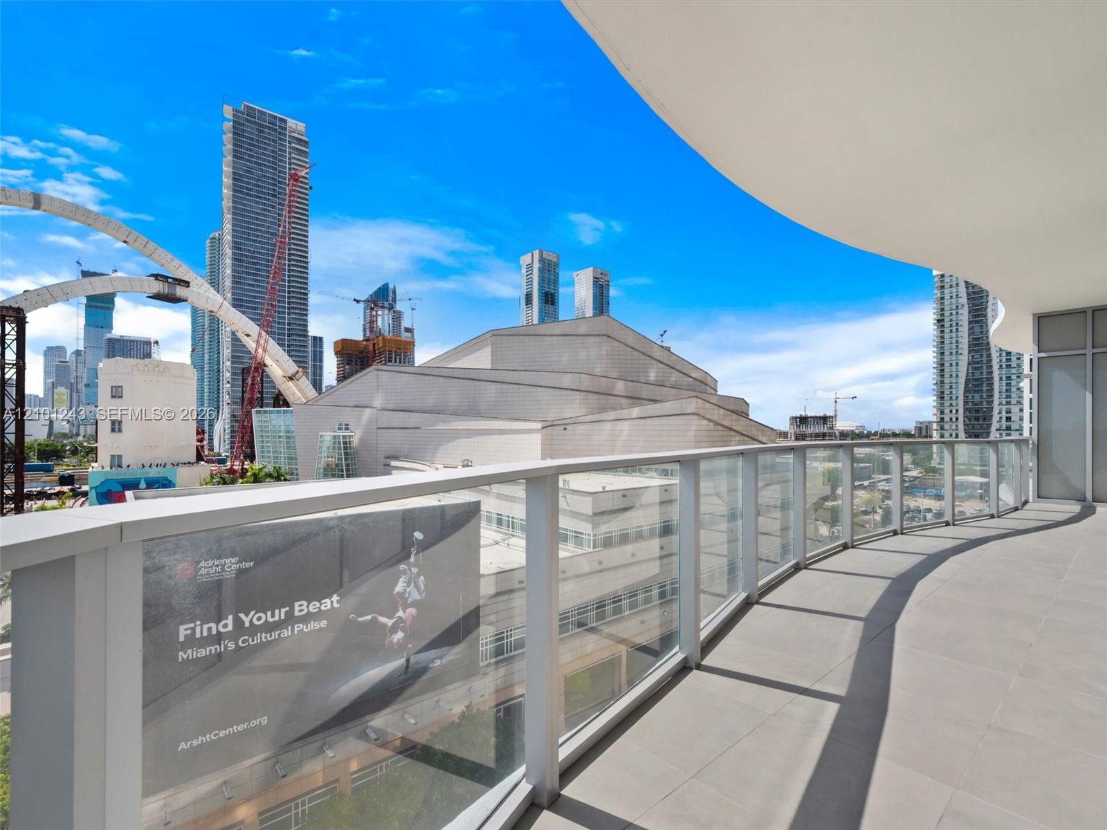 Curved balcony featuring tile flooring and a glass-paneled railing