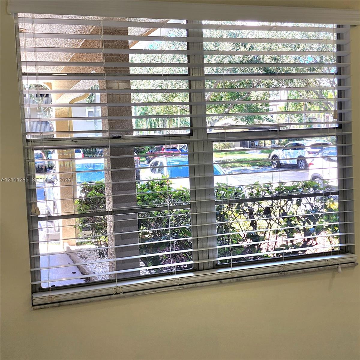 Multi-pane window featuring integrated horizontal blinds and a stone-finish sill