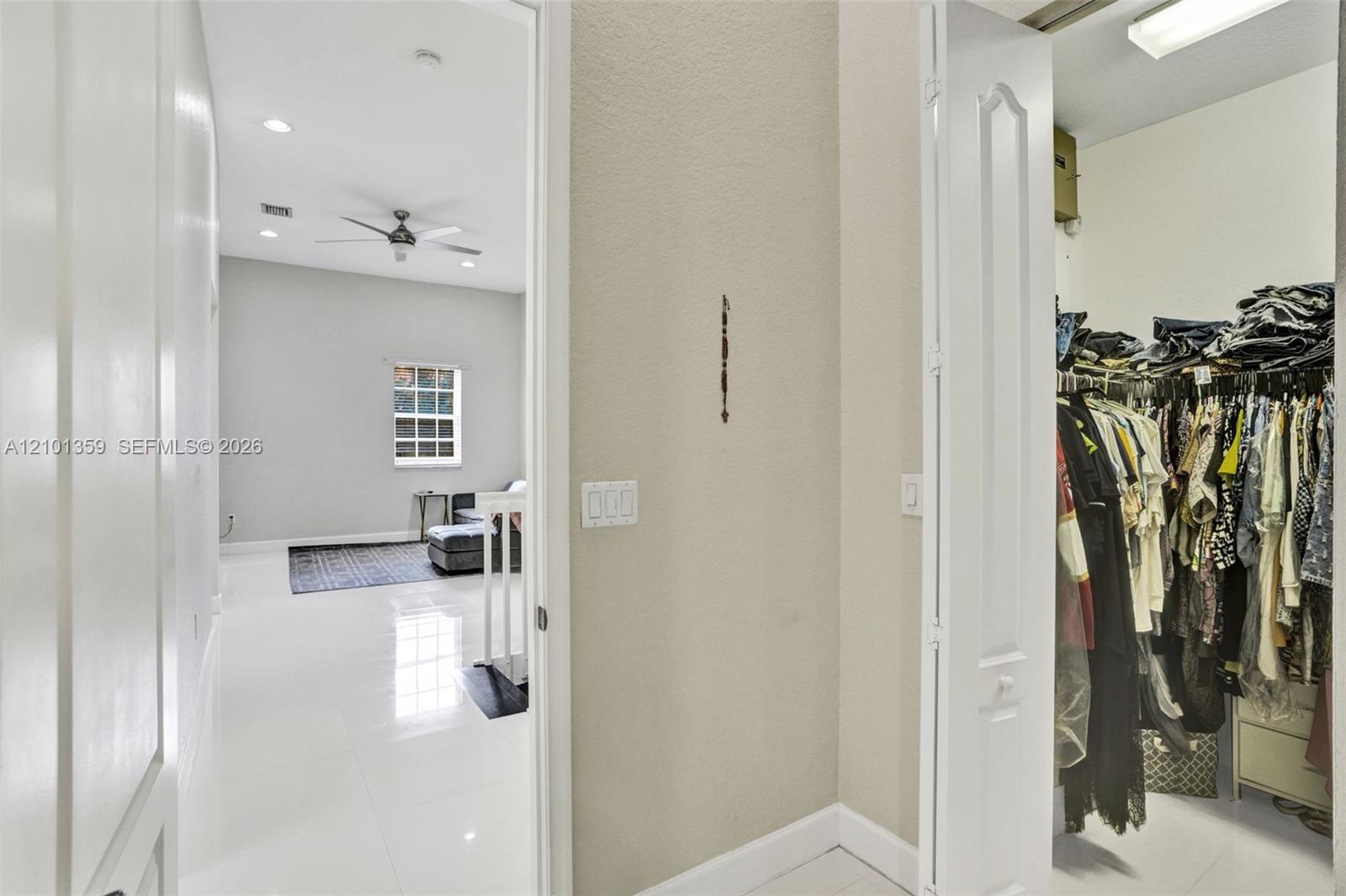 High-gloss tile flooring, recessed ceiling lighting, ceiling fan, and walk-in closet with built-in shelving