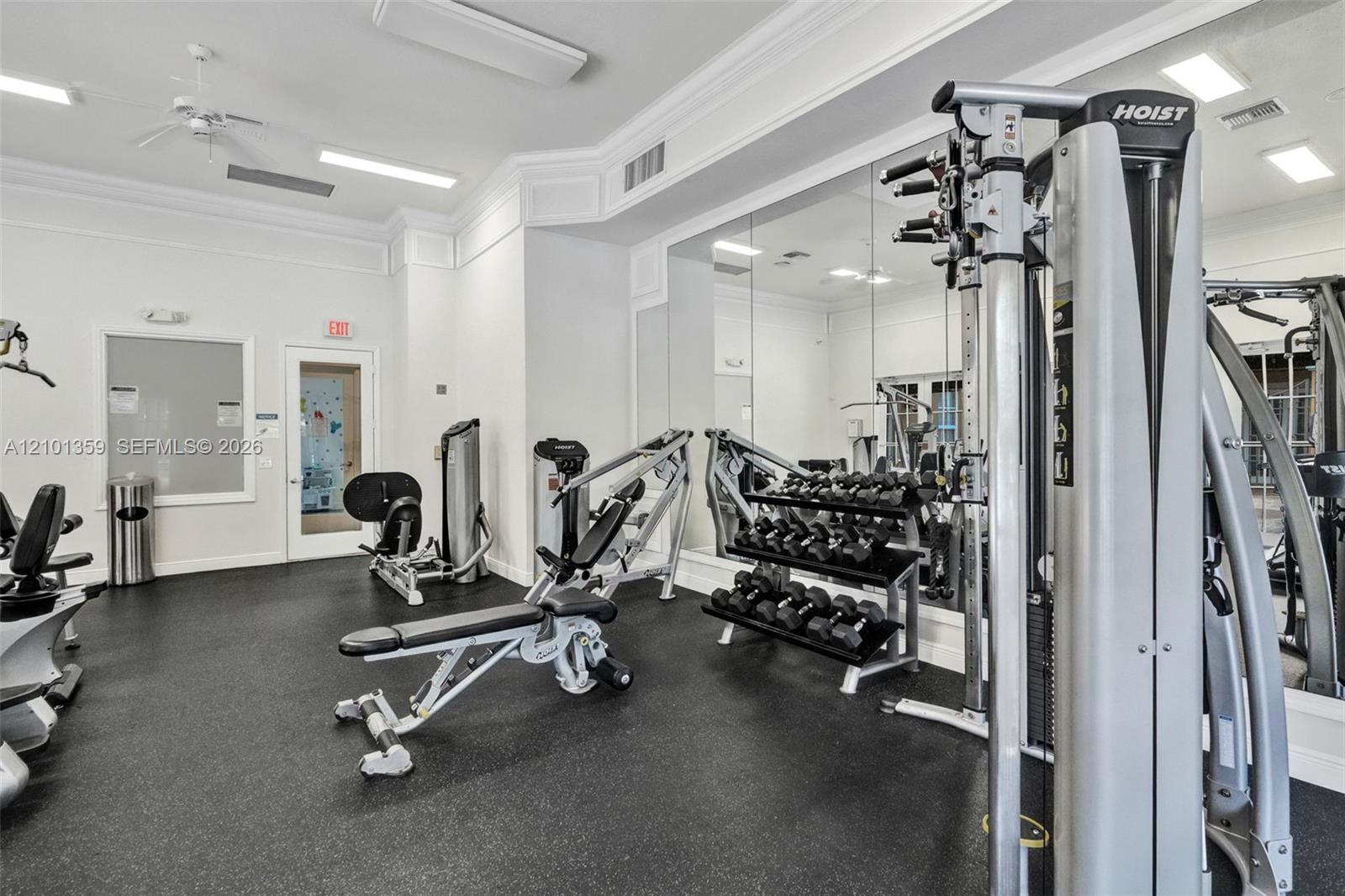 Fitness room featuring wall-to-wall mirrors, recessed lighting, crown molding, and rubberized flooring
