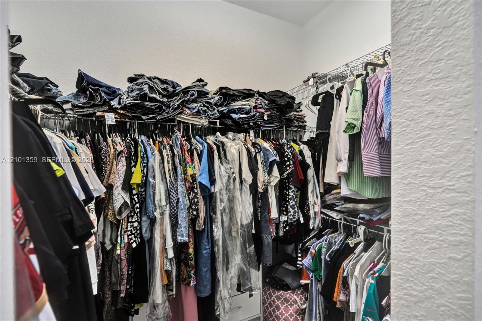 Walk-in closet featuring tiered wire shelving and integrated drawer storage