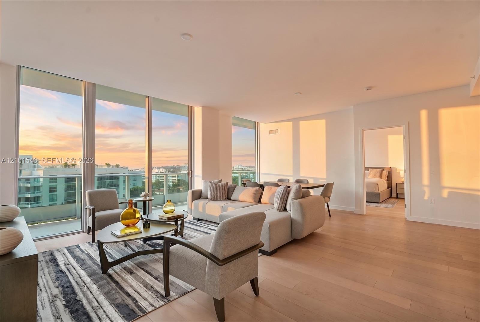 Floor-to-ceiling windows, wood-finish flooring, recessed lighting, and a glass-railing balcony Floor-to-ceiling windows, wood-finish flooring, recessed lighting, and a glass-railing balcony