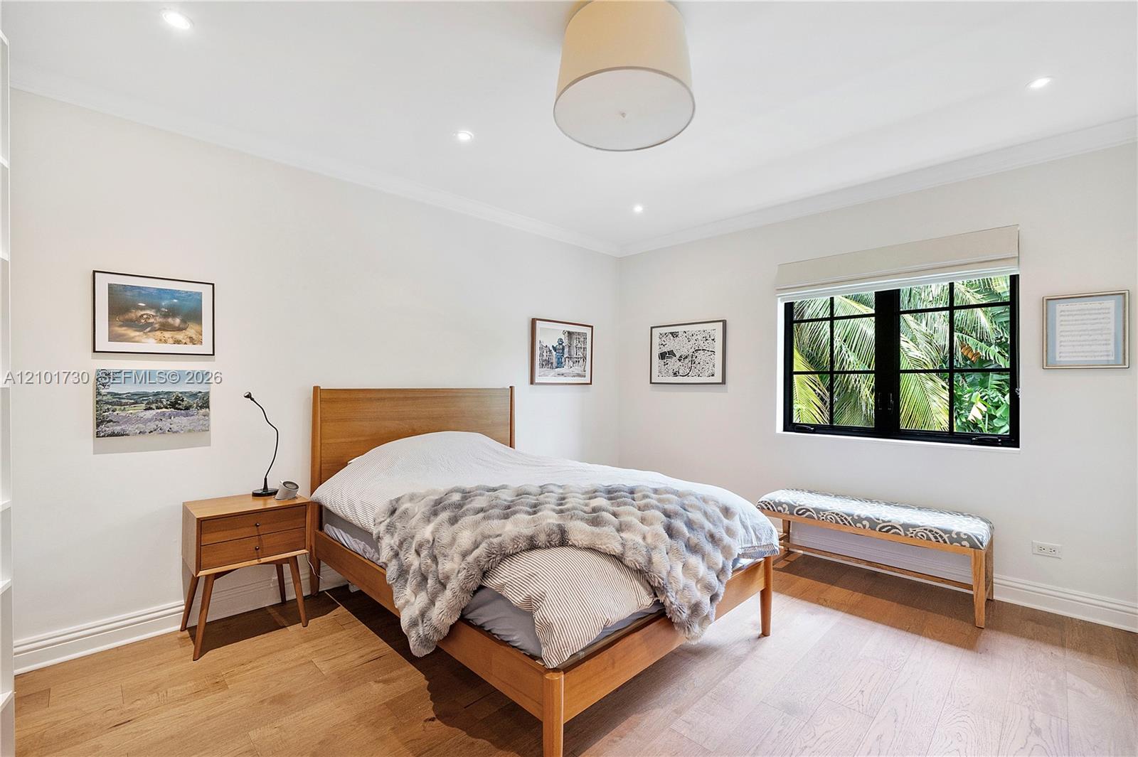 Wood-finish flooring, multi-pane window with black frame, crown molding, and recessed lighting